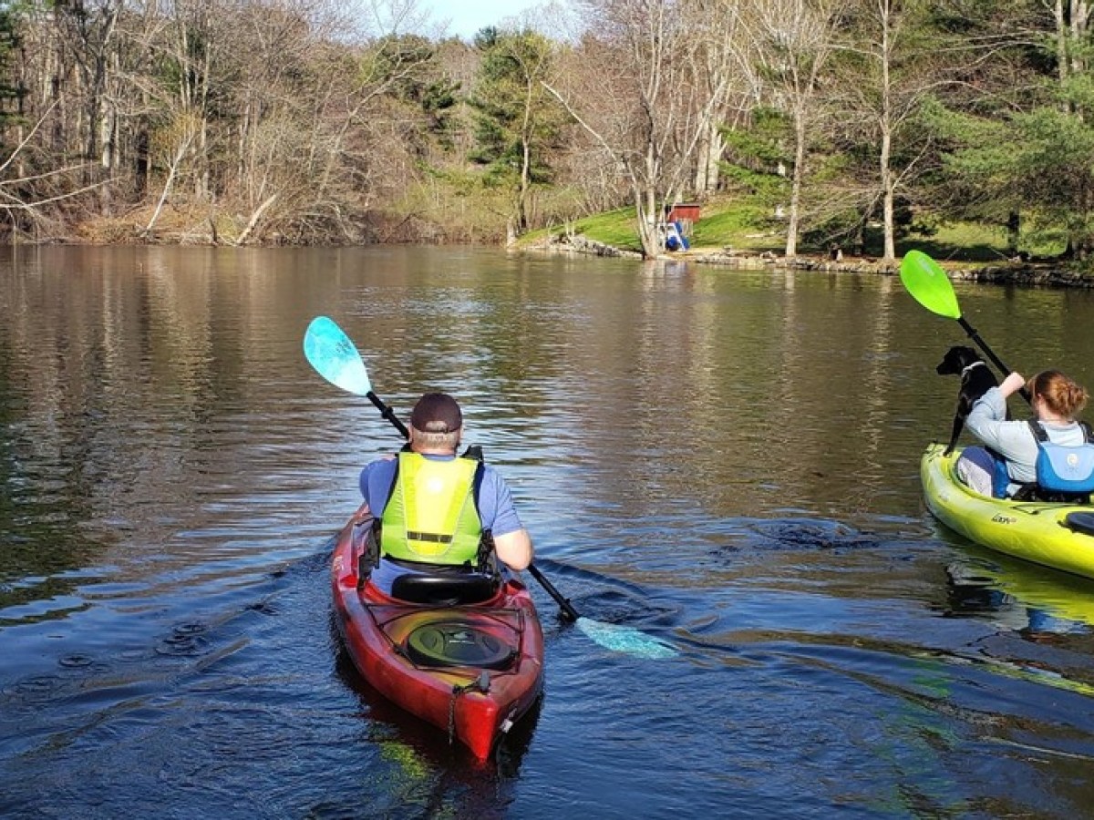 a group of people riding on the back of a boat in the water